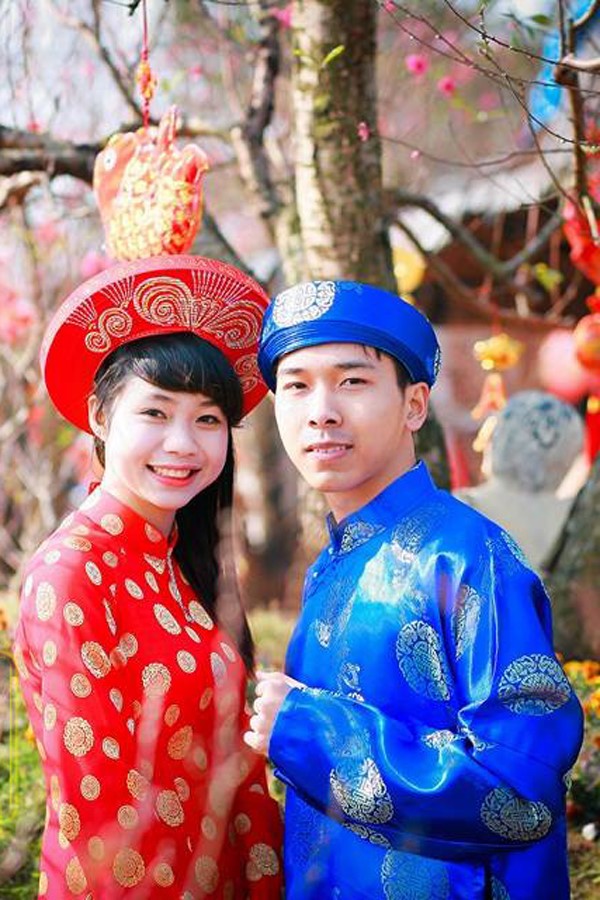 赤いアオザイを着ているベトナム人女性と男性